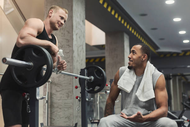 istock Man and personal trainer exercising with dumbbell 953061584