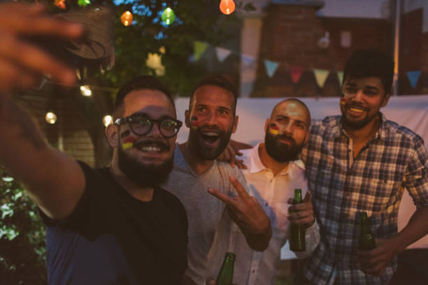istock Friends Watching Soccer Game On Big Screen In Backyard 953065110