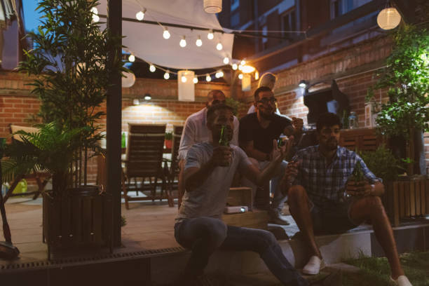 istock Friends Watching Soccer Game On Big Screen In Backyard 953065408