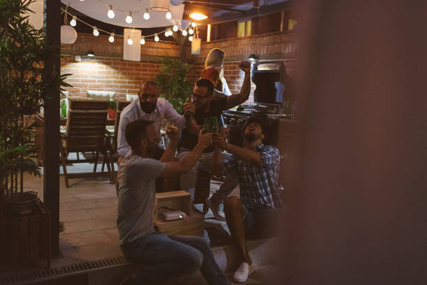 istock Friends Watching Soccer Game On Big Screen In Backyard 953065410