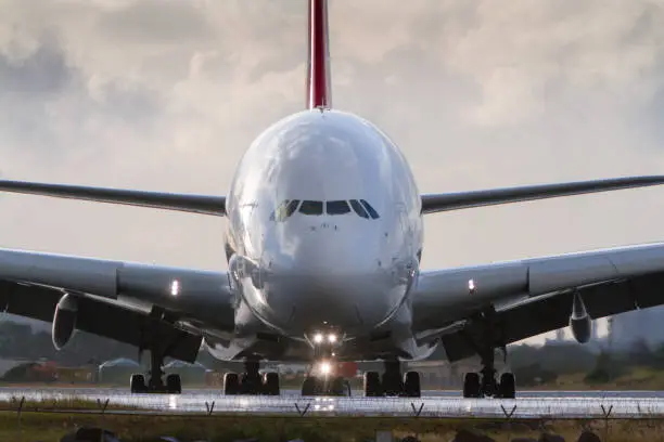 A380 jumbo jet airliner in close up front view on runway.
