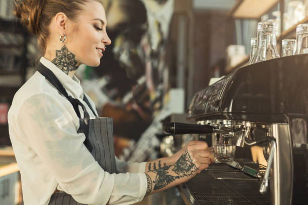 istock Tattooed barista making coffee in professional coffee machine 953069802
