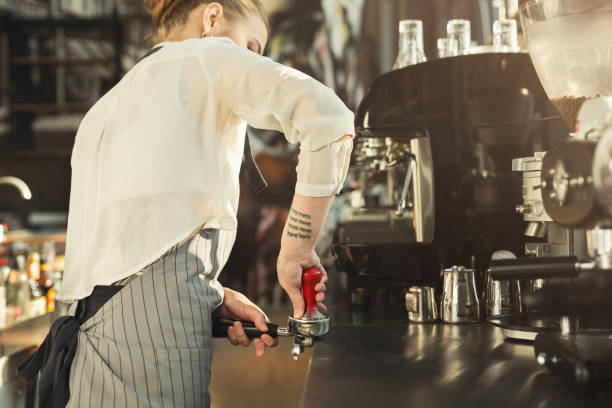 istock Tattooed barista making coffee in professional coffee machine 953069926