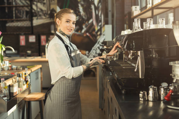 istock Tattooed barista making coffee in professional coffee machine 953069974
