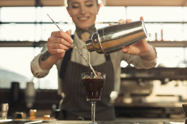 Happy barista making coffee cocktail at cafe counter
