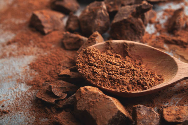 istock Crushed chocolate pieces and cocoa on gray background 953073870