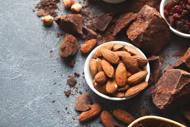 Crushed chocolate bar pieces and cocoa on gray background