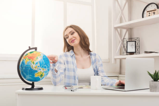 istock Woman dreaming about travel, looking at globe 953077360