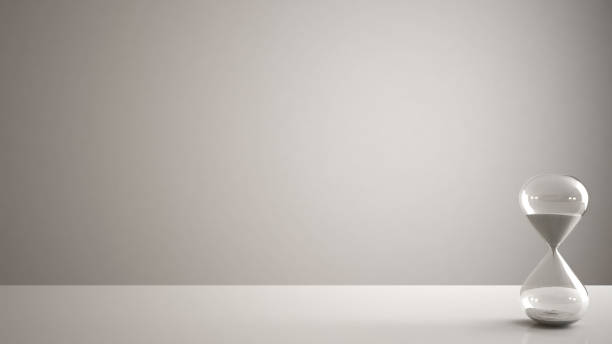 istock White table, desk or shelf with crystal modern hourglass measuring the passing time in a countdown to a deadline, white copy space background 953077848