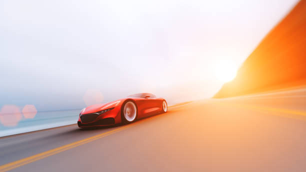istock red car driving on a road by sea 953077988