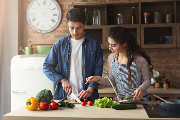 istock Happy couple cooking healthy dinner together 953078110