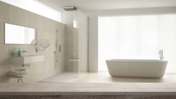 istock Wooden vintage table top or shelf closeup, zen mood, over blurred minimalist bathroom with bathtub and shower, white architecture interior design 953078708