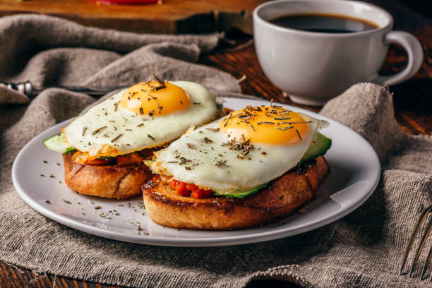 istock Italian toasts with vegetables and fried eggs on white plate and 953078898