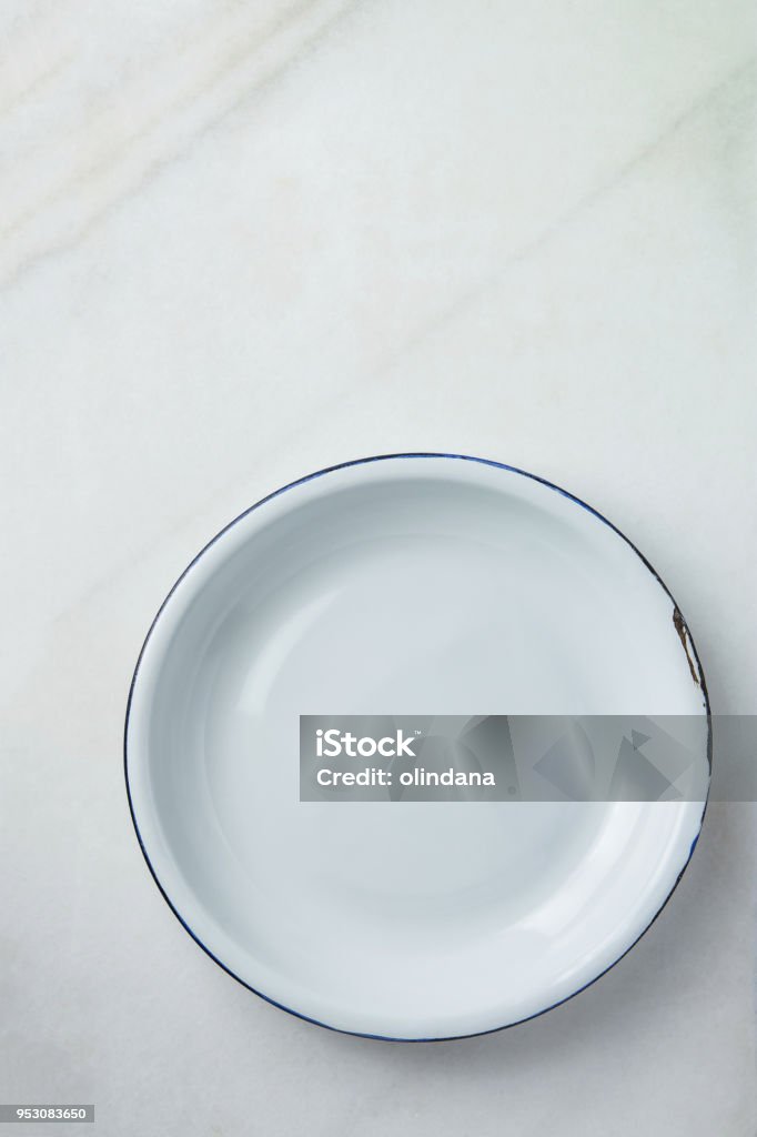 White Vintage Enamel Plate with Blue Edges on Marble Stone Background. Minimalist Style. Template for Poster Banner Cooking Baking Workshop Course. Easter Christmas Concept White Vintage Enamel Plate with Blue Edges on Marble Stone Background. Minimalist Style. Template for Poster Banner Cooking Baking Workshop Course. Easter Christmas Plate Stock Photo