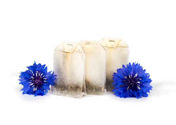 herbal tea bag with blue flowers isolated on white background