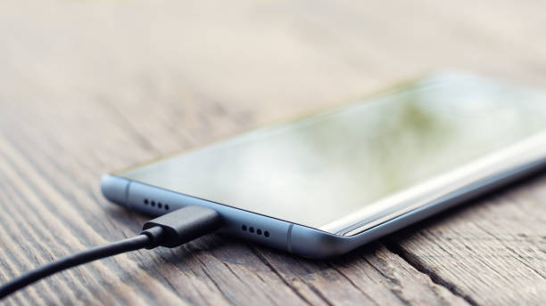 smartphone se está cargando - plug adapter charging mobile phone battery charger fotografías e imágenes de stock