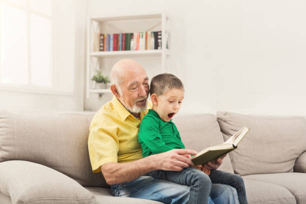 istock Senior man reading book for his grandchild 953090468