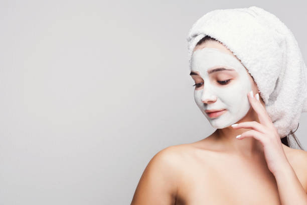 istock Beautiful girl with applied clay mask at white background 953090586