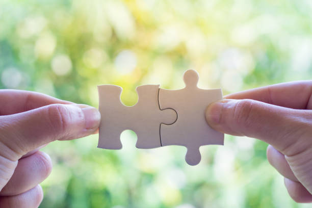 istock Closeup hand of man connecting jigsaw puzzle with sunlight effect, Business solutions, success and strategy concept 953091784