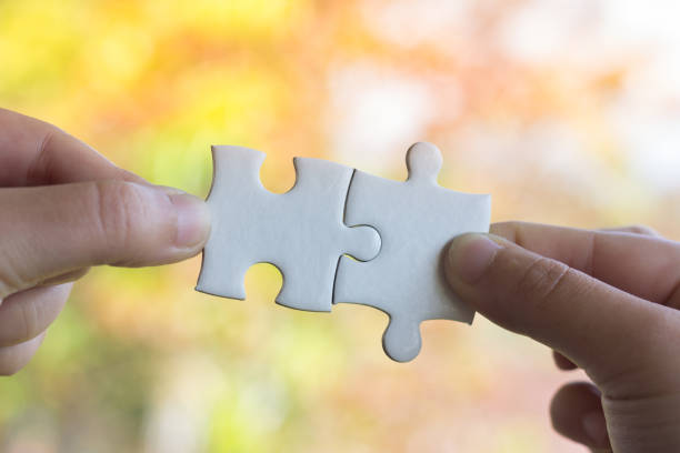 istock Closeup hand of man connecting jigsaw puzzle with sunlight effect, Business solutions, success and strategy concept 953091796
