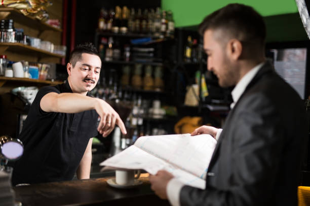 istock Barista and his friend reading newspapers 953104950