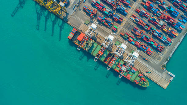 istock Container ship in export and import business and logistics. Shipping cargo to harbor by crane. Water transport International. Aerial view and top view. 953105690