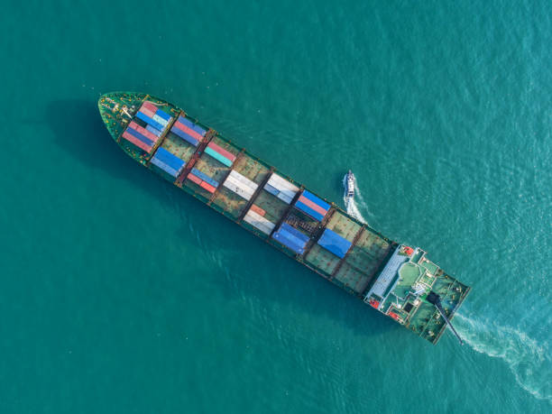 istock Container ship in export and import business and logistics. Shipping cargo to harbor by crane. Water transport International. Aerial view and top view. 953105734