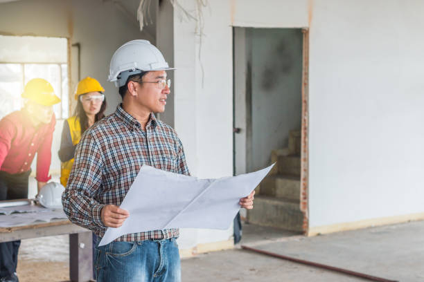 istock Portrait of engineer checking the blueprint with commitment to success at construction site 953109000