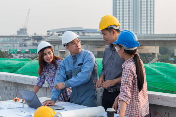 istock Group of engineer checking the blueprint with laptap and talking about construction project with commitment to success at construction site 953109100