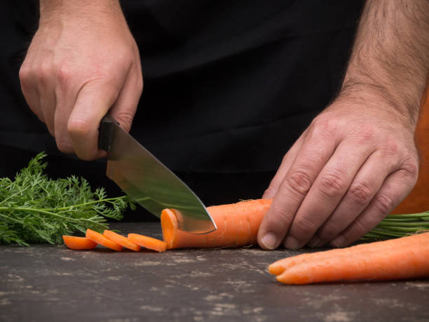 istock Cutting carrot on a stone table for meal preparation 953119140