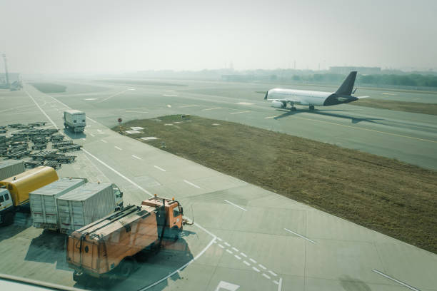 A passenger plane being serviced by ground services before next takeoff. A passenger plane being serviced by ground services before next takeoff. pushback tug, passenger boarding steps vehicle, tractor with baggage carts and minivan at airport apron. aircraft maintenance india airport stock pictures, royalty-free photos & images