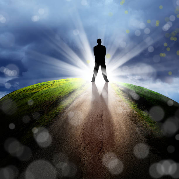 istock silhouetted businessman on empty road over glowing beam of light 953131752