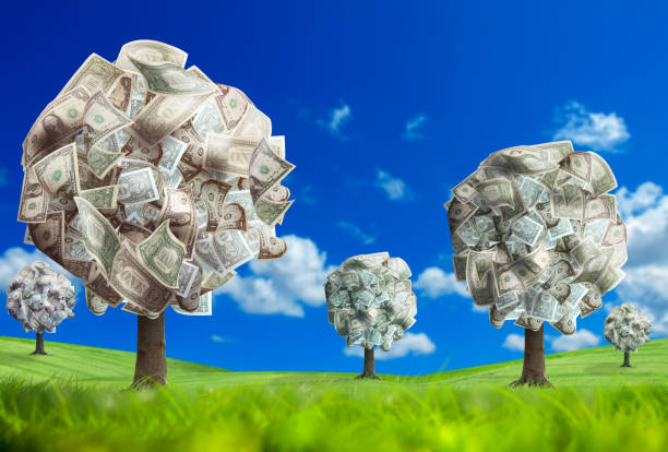 istock Conceptual image of money tree on green landscape over clear sky 953132396