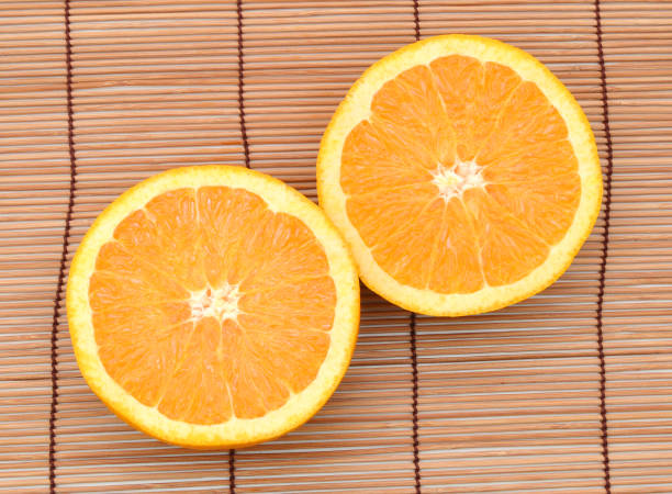 istock two half orange fruit on bamboo mat, fresh and juicy 953135508
