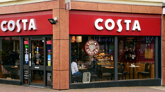 Waterlooville, UK - April 29, 2018: Costa coffee shop on the high street. Busy looking store front with advertising and seating. People inside are discernible. Costa logo clearly visible above.