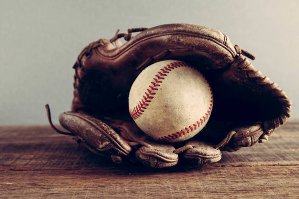 nahaufnahme des baseballballballs im handschuh auf dem tisch - baseball glove baseball baseballs old fashioned stock-fotos und bilder