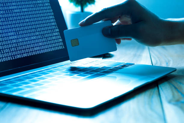 The concept of credit card theft. Hackers with credit cards on laptops use these data for unauthorized shopping. Unauthorized payments from credit card owners. In the hacker's secret office stock photo