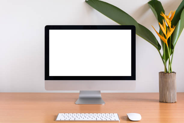 istock All in one computer, mouse, keyboard, clock, pencils, and flowers vase  on wooden table 953147186