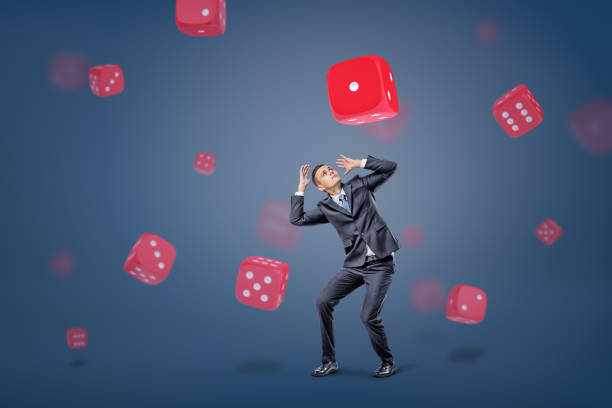 istock A small businessman hides from large red and white gambling dice falling on him on a blue background 953155950