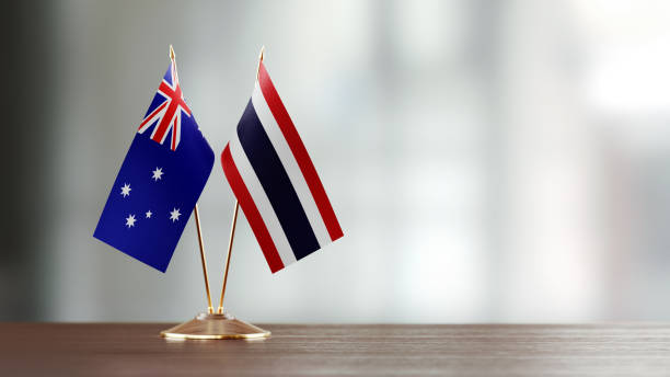istock Australian And Thai Flag Pair On A Desk Over Defocused Background 953164684