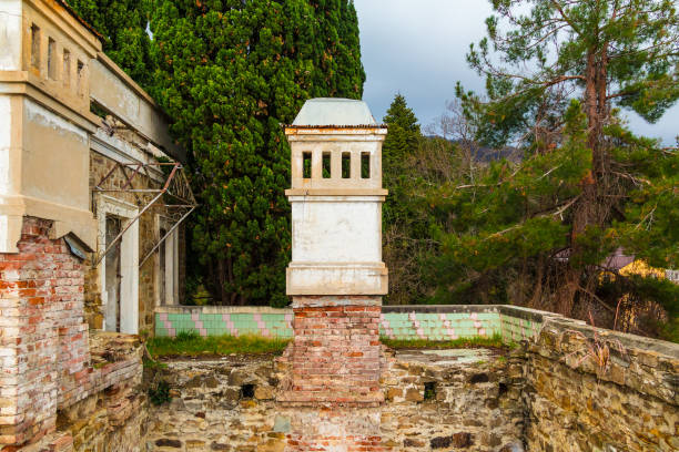 Chimney of abandoned old mansion called Dacha Kvitko among the thicket in overcast day, Sochi, Russia