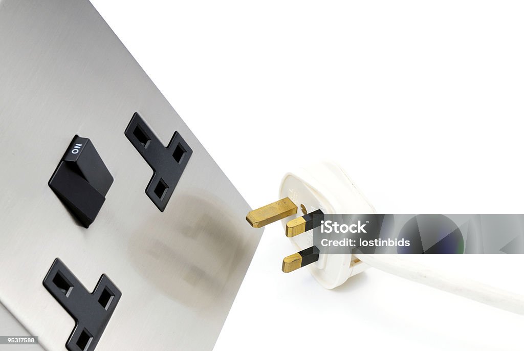 UK Electric Plug and Stainless Steel Socket A UK electiric plug and stainless steel socket isolated on white. Electrical Outlet Stock Photo