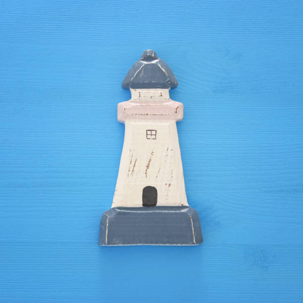 istock vacation and summer image with lighthouse over blue wooden background. 953188094