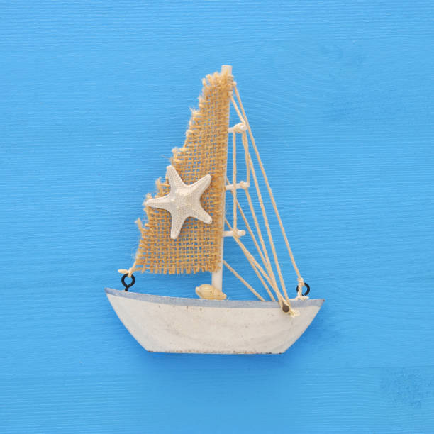 istock vacation and summer image with boat over blue wooden background. 953188110