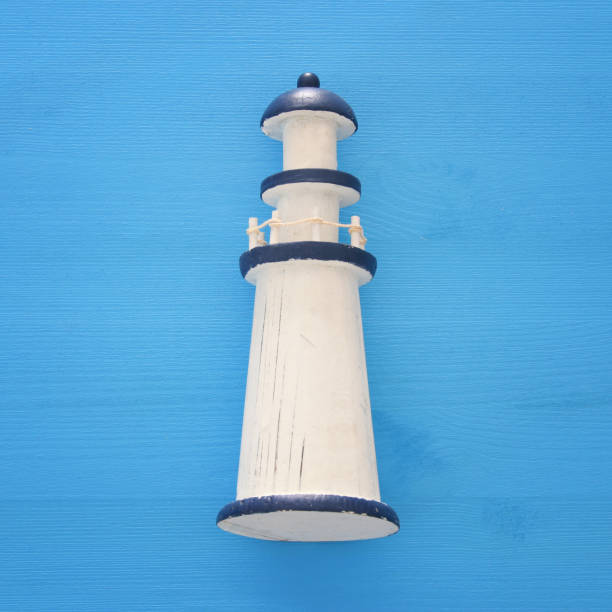 istock vacation and summer image with lighthouse over blue wooden background. 953188120