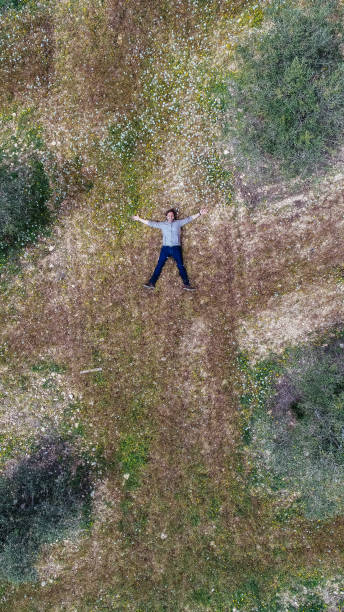 istock Aerial view of a man lying in a field 953190152