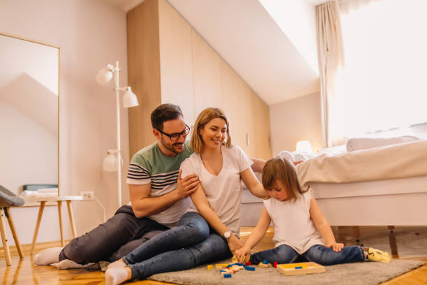 istock Young parents are watching their daughter while she is playing on the floor 953193416