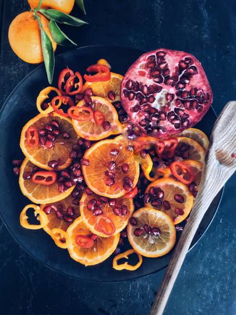 istock Oranges and pomegranate on black plate 953196226