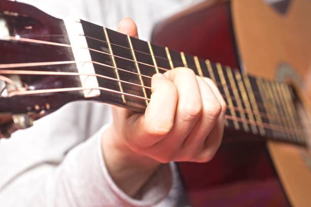 istock Young woman's hands playing a acoustic classic guitar 953196284