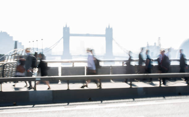 London, UK. Blurred image of office workers crossing the London bridge in early morning on the way to the City of London. Tower bridge at the background. London, UK. Blurred image of office workers crossing the London bridge in early morning on the way to the City of London. Tower bridge at the background. Rush hours tower bridge london england bridge europe stock pictures, royalty-free photos & images